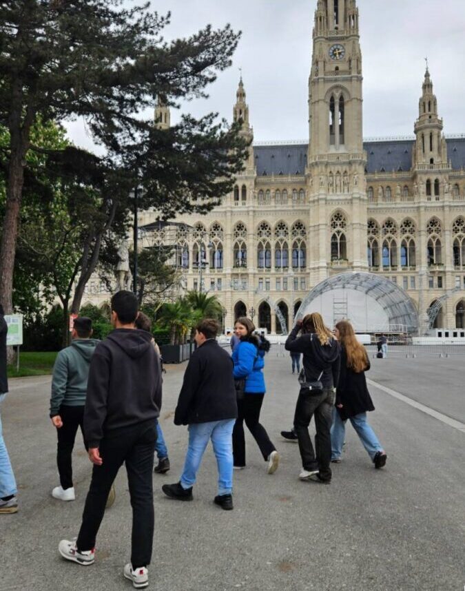 Eine Gruppe Jugendlicher geht über den Rathausplatz, im Hintergrund ist das Rathaus zu sehen.