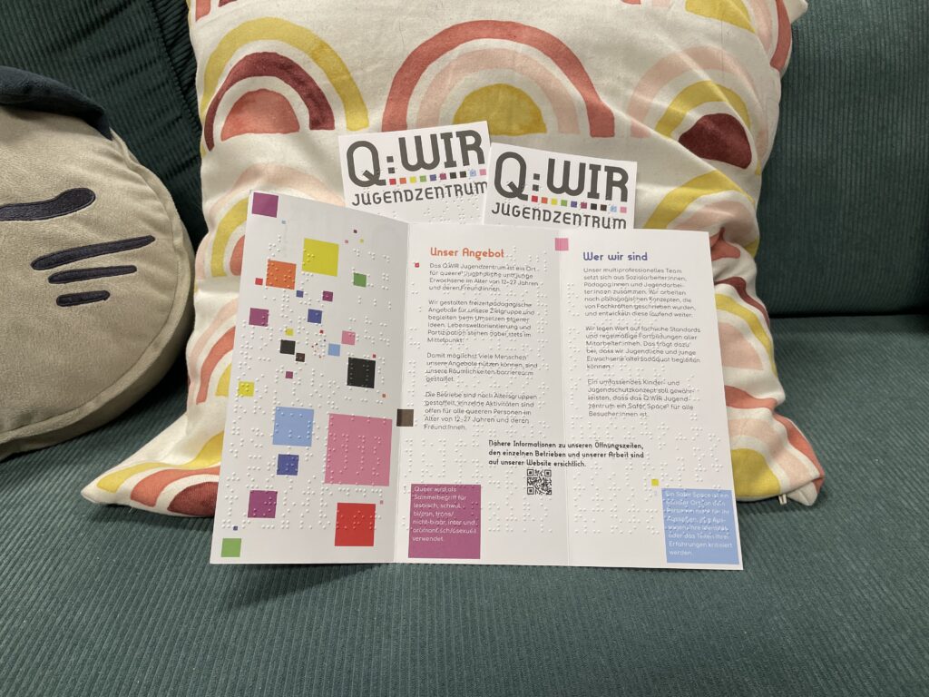 Faltfolder mit Informationen auch in Brailleschrift ist auf einm Polster auf platziert