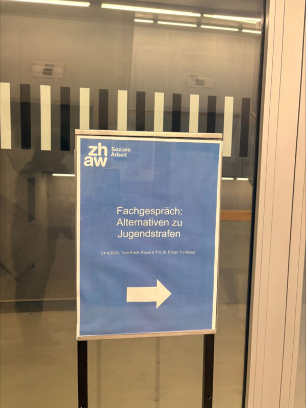 Ein blaues Hinweisschild der ZHAW Soziale Arbeit mit einem weißen Pfeil nach rechts. Auf dem Schild steht: „Fachgespräch: Alternativen zu Jugendstrafen“ sowie ein Raum- und Datumshinweis für das Toni-Areal am 24.4.2026.